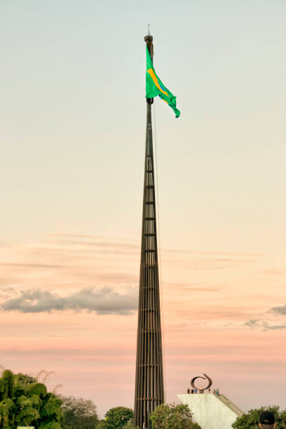 White flag attached to a flagpole waving on the sky