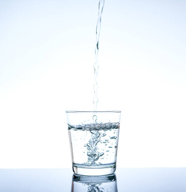 istock Pouring water and splashing in the glass with reflection on mirror. 845194380