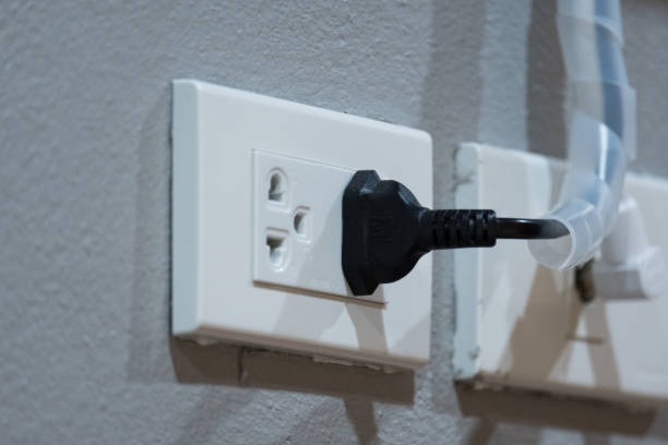 istock Electrical plug (left) and TV signal plug (right) on grey cement background 845212540