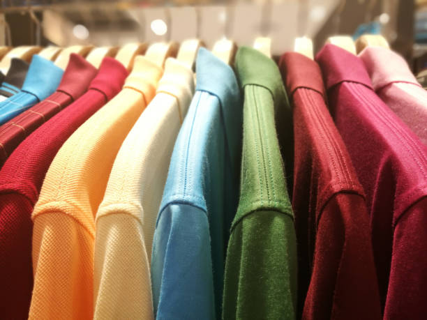 Mens shirts in different colors on hangers in a retail clothes store Mens shirts in different colors on hangers in a retail clothes store garment store fashion rack stock pictures, royalty-free photos & images