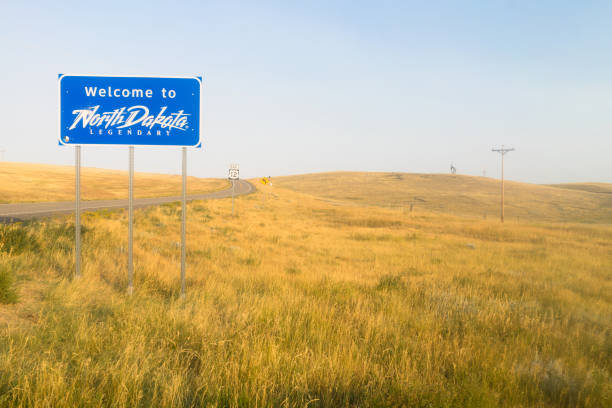 Welcome to Legendary North Dakota Road Entry Sign The scene is all blue and yellow at an entrance to North Dakota Road Sign north dakota stock pictures, royalty-free photos & images