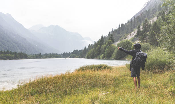 istock Man pointing with hand near the lake in rain 845232630