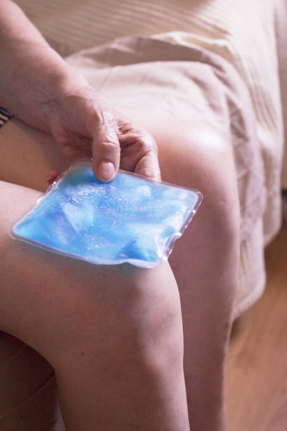 alte frau mit eis auf knie gegen schmerzen und entzündungen - ice women ice pack physical injury stock-fotos und bilder
