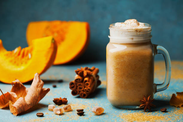 istock Fresh pumpkin spiced latte or coffee in cup decorated cinnamon on blue vintage background. Autumn, fall or winter hot drink. 845271102