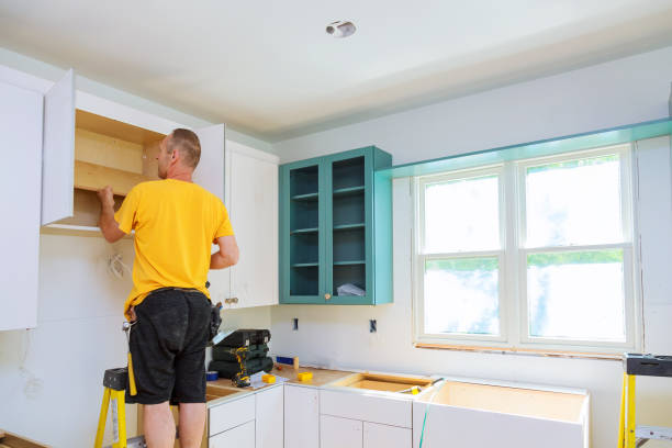 istock Installation of kitchen. Worker installs doors to kitchen cabinet. 845274158