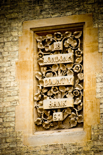 The elaborate carved insignia for the now defunct London County Bank. This is near St John's College, Cambridge, UK.