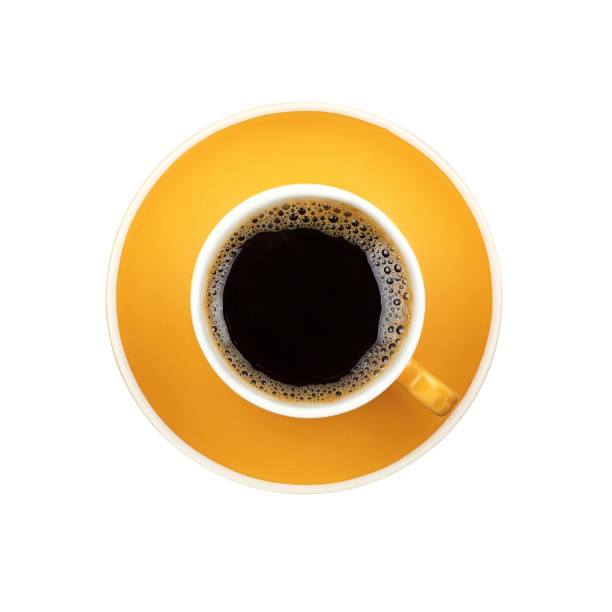 Americano yellow cup and saucer isolated on white Full Americano black filtered coffee in small yellow cup with saucer isolated on white background, elevated top view, close up black coffee from above stock pictures, royalty-free photos & images