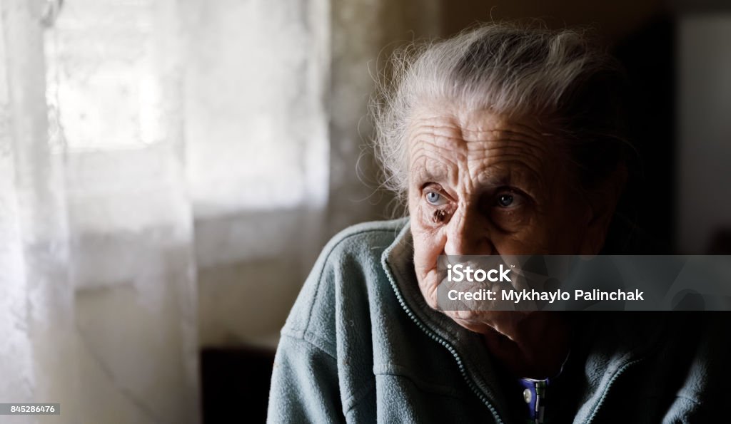 very old tired woman Portrait of a very old tired woman sitting near a window 70-79 Years Stock Photo