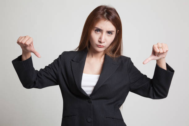 istock Unhappy Asian girl show thumbs down with both hands. 845287004