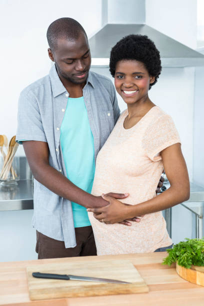 istock Man touching pregnant womans stomach in kitchen 845292416