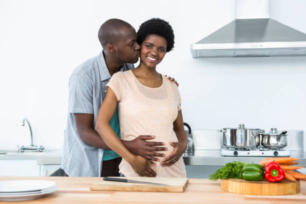 istock Pregnant couple embracing in kitchen 845292440
