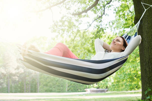 Woman Relaxing In Hammock Young Happy Woman Relaxing In Hammock At Garden hammock relaxation women front or back yard stock pictures, royalty-free photos & images