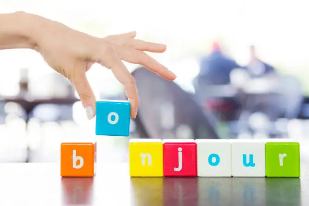 Bonjour word and human hand holding toy block
