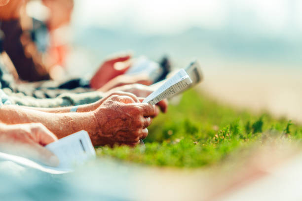 Hands of men with betting magazines on a racecourse