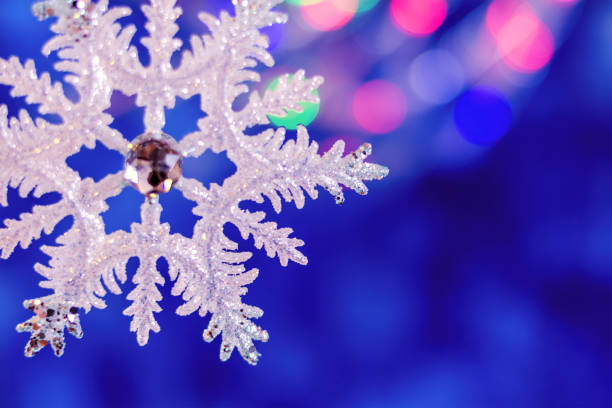 istock Christmas snowflake on a blue, selective focus at the bottom of picture. 845305214