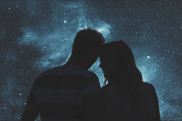 silhuetas de um jovem casal sob o céu estrelado. meu trabalho de astronomia. - stars in your eyes - fotografias e filmes do acervo