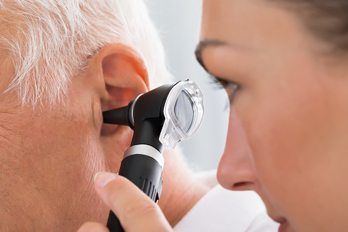 Doctora examinando el oído del paciente photo