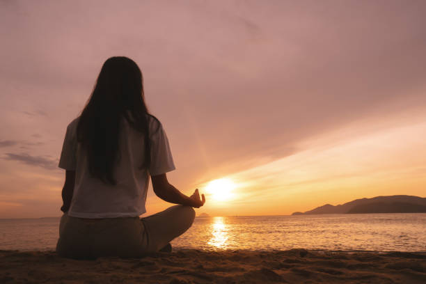 istock Young woman practicing yoga on the beach at sunrise. 845307820
