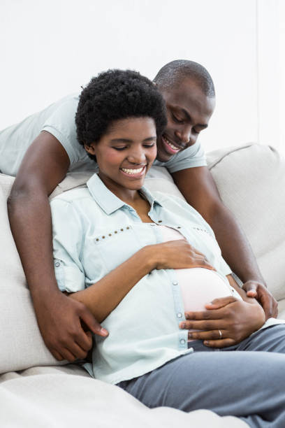 istock Man embracing pregnant woman from behind 845317162