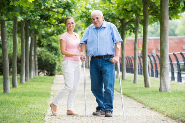 istock Woman With Her Disabled Father Standing In Park 845323214