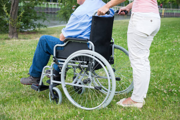 istock Woman Assisting Disabled Man On Wheelchair 845323678