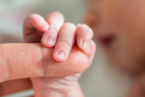 Close-up Photo Of Baby Holding Mother's Finger