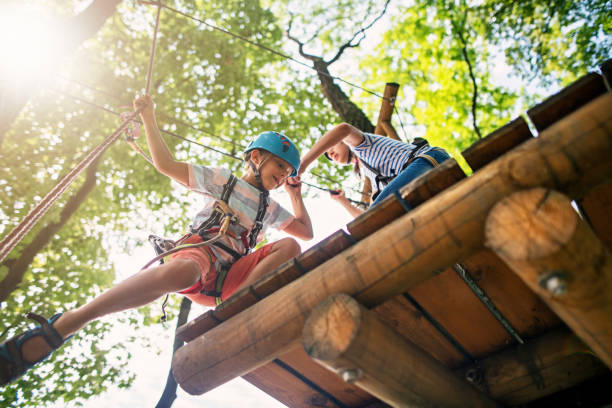 Little girl helping her brother on ropes course