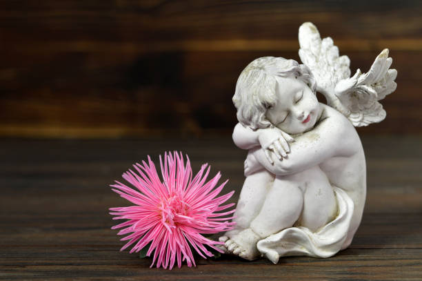 istock Sleeping angel and flower on wooden background 845347588