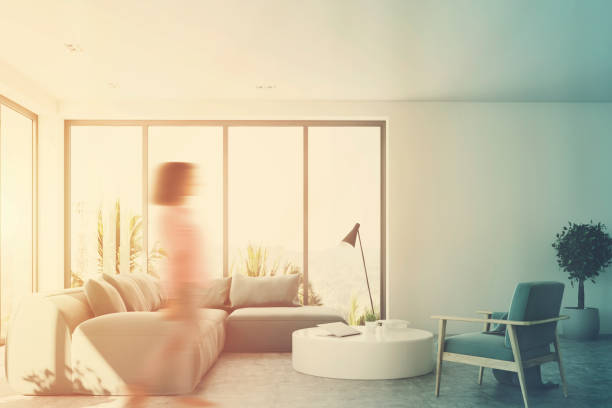 istock White living room with a blue sofa, front, girl 845347902