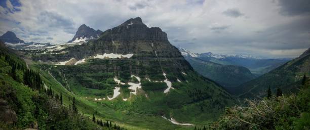 Going to the Sun Road, View of Landscape, snow fields In Glacier National Park around Logan Pass, Hidden Lake, Highline Trail, which features waterfalls, wildlife, and is surrounded by mountains including: Piegan, Pollock, Oberlin, Clements, Reynolds and Heavy Runner Mountain Montana USA va a la carretera del sol, vista del paisaje, campos de nieve en parque nacional los glaciares alrededor de logan pass, lago escondido, camino de highline, que cuenta con cascadas, flora y fauna y está rodeado por montañas como: pollock, oberlin, piegan, clements, reynolds