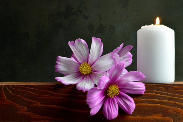 istock White burning candle and flowers 845348364