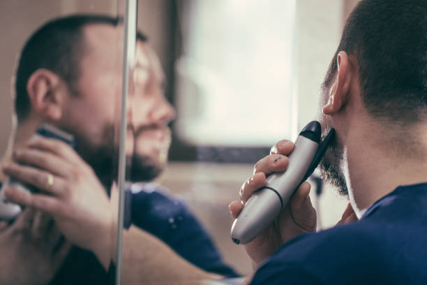istock Man shaving with electric razor in bathroom 845373534