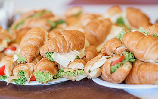 Butter croissants with chicken ham, cheese and parsley on white plate.Croissant sandwich with cheese and vegetables for healthy snack.Appetizer