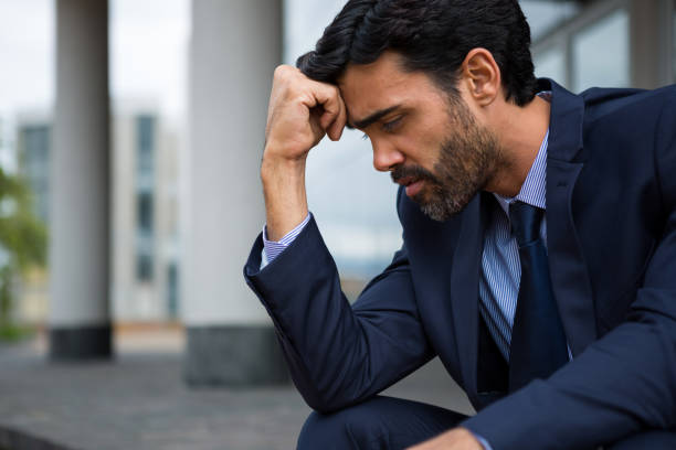 istock Depressed businessman sitting with hand on forehead 845396780