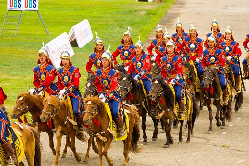 Soldiers in uniform on horseback participating in the opening ceremony of the Naadam Festival