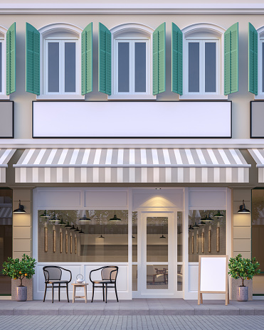 The front of the street shop 3d rendering image.There are a street shop, the building has classic style and pastel color scheme. The front store has footpaths and table sets.