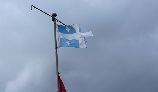 Rasgado para arriba la bandera de Quebec en mástil completo con visible debajo de la bandera de Canadá photo
