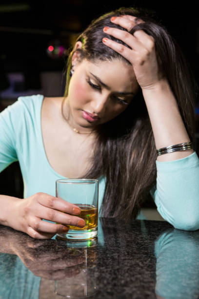 istock Depressed woman having whiskey at bar counter 845443798