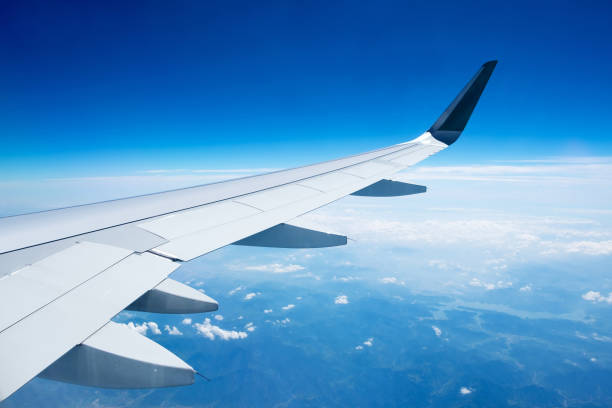 istock Close-up of airplane wing flying above clouds 845449570
