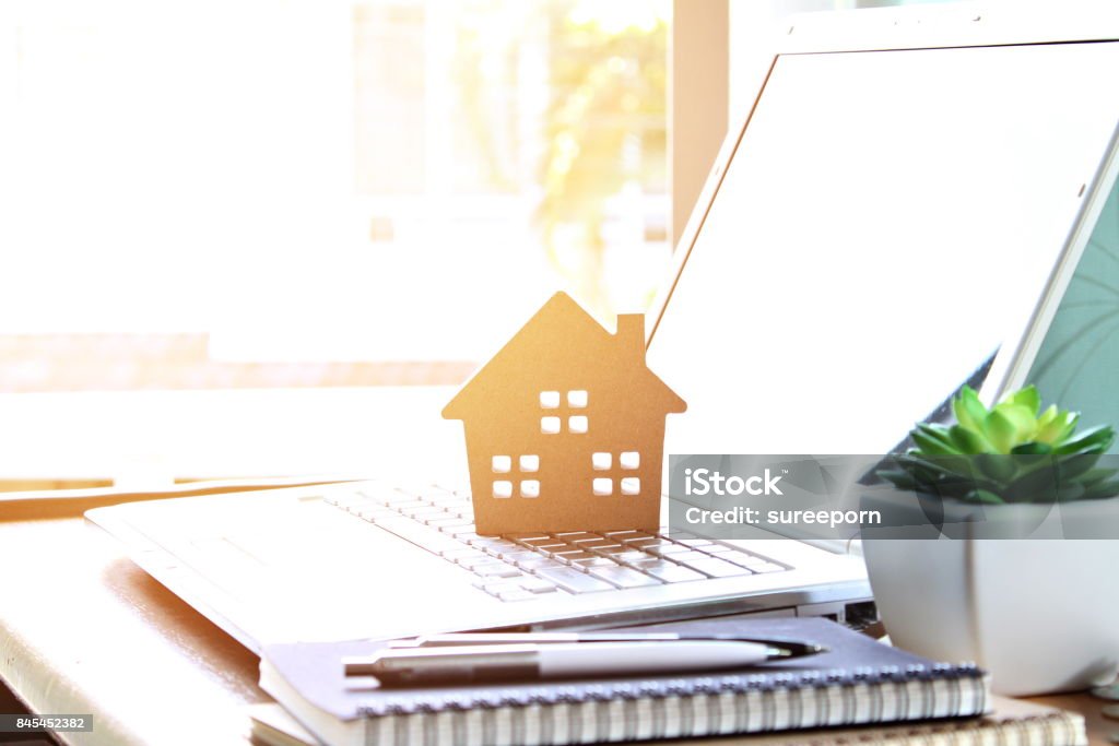 Wood house model on computer laptop Business, finance, savings, property ladder or mortgage loan concept : Wood house model on computer laptop Real Estate Stock Photo