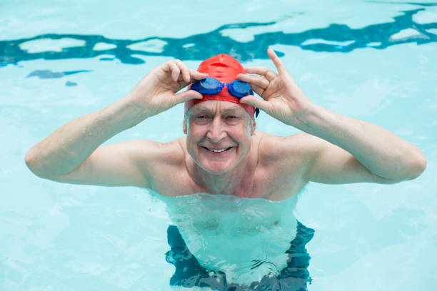 istock Happy senior man holding goggles in swimming pool 845452644