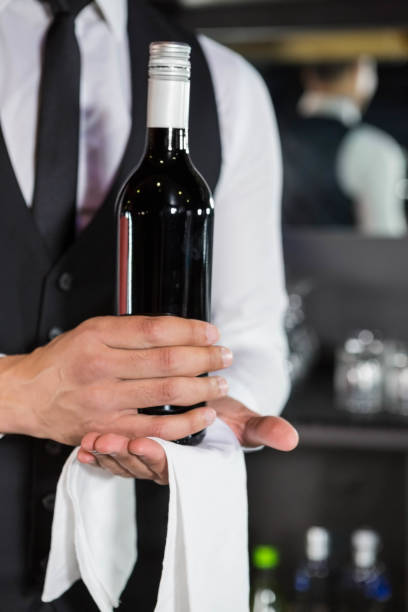istock Mid section of bartender holding a wine bottle 845455108