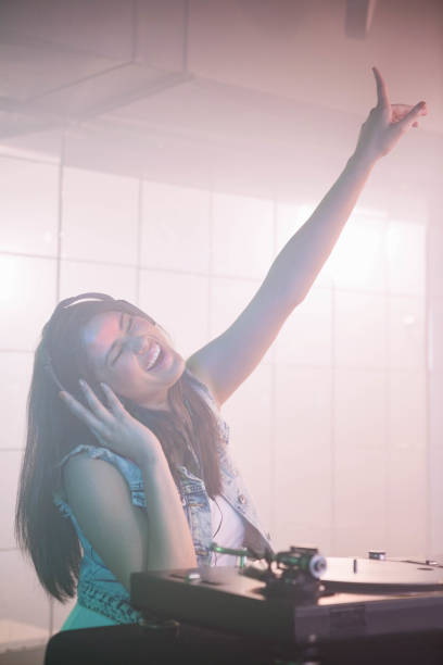 istock Pretty female DJ waving her hand while listening music 845455164