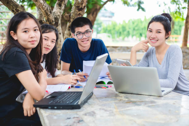 istock Asian Group of students sharing with the ideas for working on the campus lawn 845460858