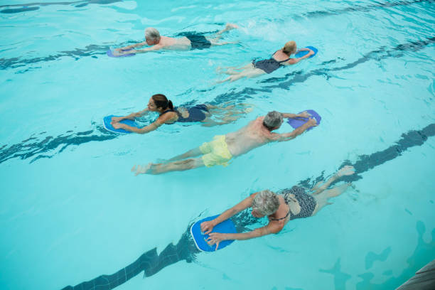 istock Senior swimmers with instructor swimming in pool 845470514