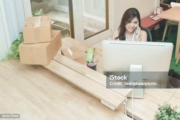 Young Entrepreneur Working On The Smart Computer While Talking To Her Customer At Home Office Stock Photo - Download Image Now