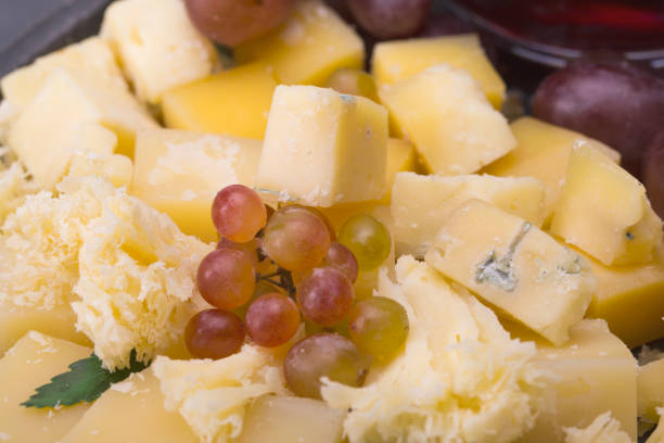 istock Set of cheeses with grapes and red wine on a dark background. 845471456