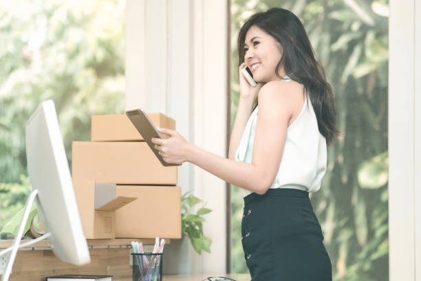 istock Young entrepreneur checking products stock on the smart tablet while talking to her customer at home office 845471504