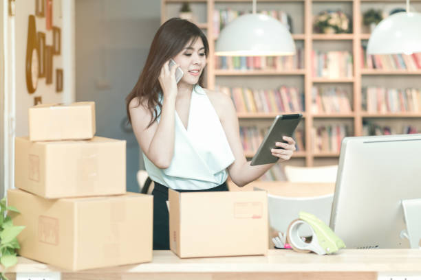 istock Young entrepreneur checking products stock on the smart tablet while talking to her customer at home office 845471512