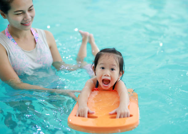 istock Close up mother teaching kid in swimming pool. 845471538